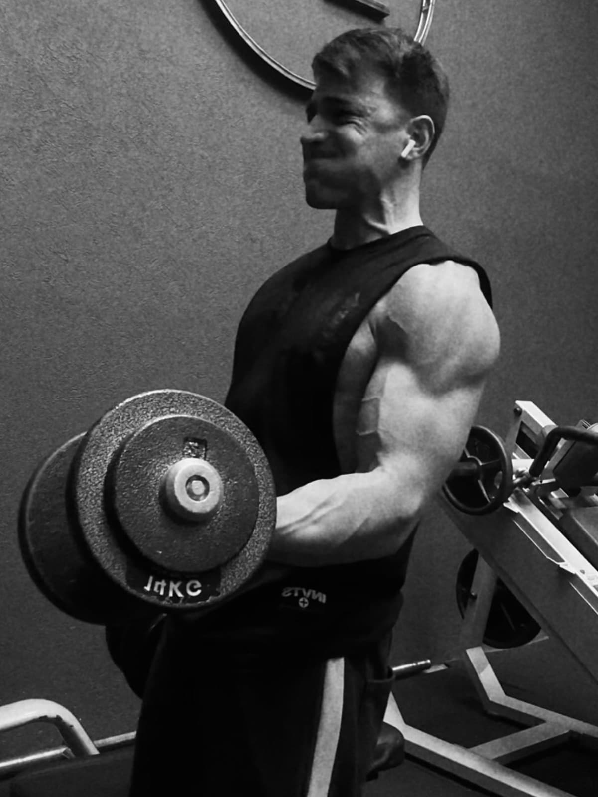 Tomás haciendo curl con mancuerna en blanco y negro